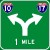 [road sign: green square with a white arrow that goes up then splits with one arrow bending left and one bending right; below the arrow are the words '1 MILE'; above the left is an interstate logo with the number '10'; above the right is an interstate logo with the number '17']